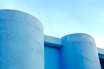 Modern blue architectural cylinders against clear sky