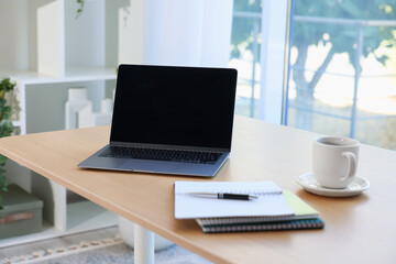 Fototapeta premium Home workspace. Modern laptop and stationery on wooden desk indoors