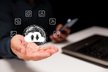 A person holds a hand out, visualizing cloud storage with icons representing data transfer and connectivity, alongside a laptop in the background.