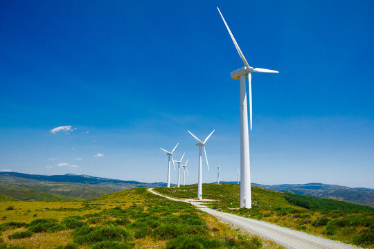 Wind turbines on a scenic hillside wind farm - Powered by Adobe