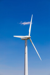 Scenic view of a wind turbine against clear blue sky
