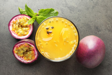 Tasty passion fruit drink with mint and fresh fruits on grey table, flat lay
