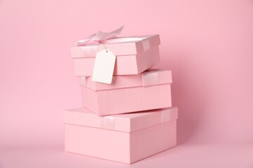 Gift boxes with blank tag on pink background