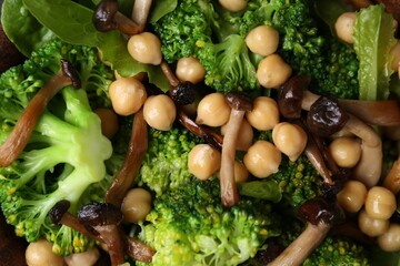 Delicious salad with shimeji mushrooms, chickpeas and broccoli as background, top view
