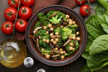 Delicious salad with shimeji mushrooms, chickpeas and broccoli served on wooden table, flat lay