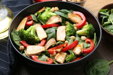 Tasty salad with eryngium mushrooms served on wooden table, closeup