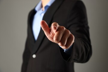 Man touching something on grey background, closeup