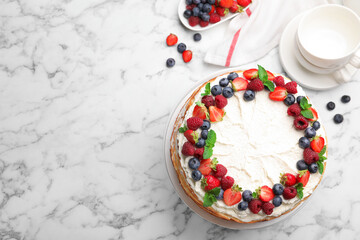 Delicious crepe cake with fresh berries on white marble table, flat lay. Space for text