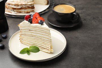 Piece of tasty crepe cake with berries served on grey table, closeup