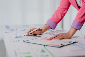 Young beautiful asian businesswoman holding unofficial spreadsheet paper accounting documents...