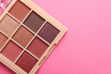 Beautiful eyeshadow palette on pink background, top view. Space for text