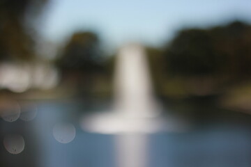 A dreamy view of a water fountain in the park.