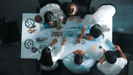 Top down view of skilled engineer showing and talking about turbine engine design. Aerial view of...