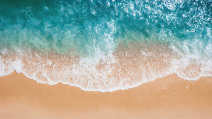 Aerial view of turquoise ocean waves gently crashing on a pristine sandy beach, creating a mesmerizing pattern of white foam, inviting relaxation and tranquility
