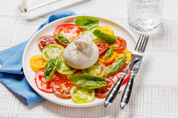 Fresh burrata served on slices of colorful tomatoes