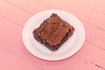 A slice of dark chocolate cake with layers of moist sponge, glossy ganache, and a fresh raspberry garnish on a white plate
