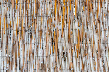 A fence made of sticks and wire. The fence is brown and white