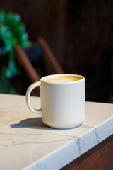 Warm cappuccino in a cup with heart-shaped latte art on top