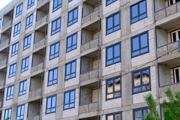 Modern apartment building under construction showing balconies and windows