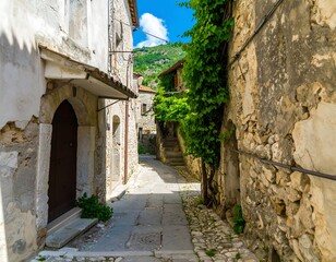 Obraz premium Narrow alleyway in a historic Italian village, sunlight, greenery