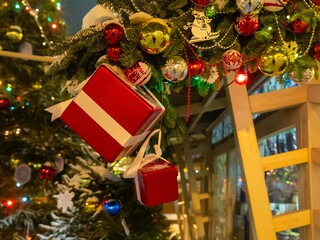 A Christmas tree with a red box hanging from it