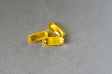 vitamins omega 3 6 9 in capsule form lie on a neutral background
