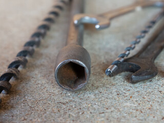Three tools are shown on a grey surface. The first is a wrench, the second is a pair of pliers, and the third is a pair of clippers.