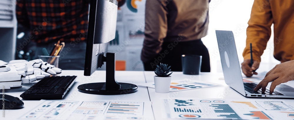 Poster a modern office environment showcasing a business team engaged in data analysis, using technology an
