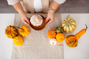 Pumpkin cake in woman hands on kitchen table for Harvest Festival