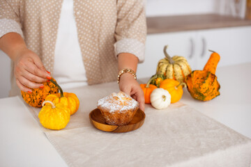 Pumpkin cake on kitchen table, woman making Thanksgiving and Fall season concept