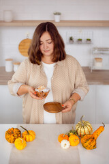 woman holding pastries, mini pumpkin cake in woman hands in kitchen