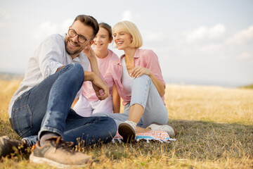 Family enjoying a sunny day outdoors in a serene grassy meadow