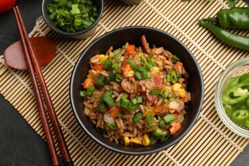Delicious fried rice in bowl served on grey table, flat lay