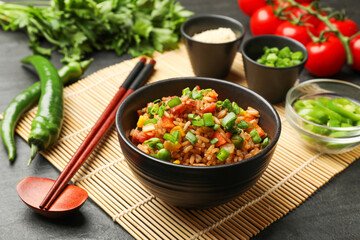 Delicious fried rice in bowl served on grey table, closeup