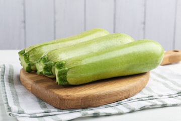 Fresh ripe zucchinis on white wooden table, closeup