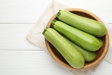 Fresh ripe zucchinis on white wooden table, top view. Space for text