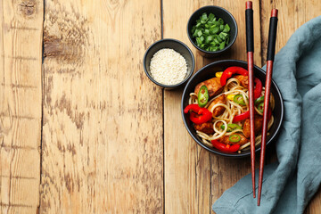 Tasty noodles with chicken and vegetables served on wooden table, flat lay. Space for text