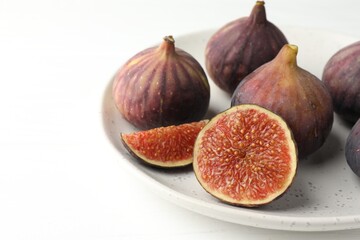 Whole and cut figs on white table, closeup