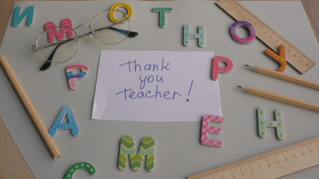 Colorful letters and stationery surround a handwritten note expressing gratitude to a teacher, showcasing a heartfelt appreciation scene. Thank you teacher 