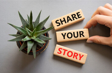Share your story symbol. Wooden blocks with words Share your story. Beautiful grey background with...