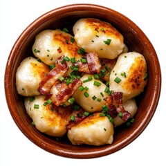 Delicious homemade potato dumplings topped with crispy bacon and chopped green onions served in a rustic earthenware bowl