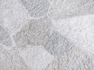 Close-up of a light grey flagstone patio with irregular shapes and visible grout lines.