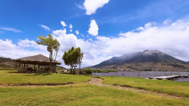 Incre&iacute;ble timelapse del gran lago San Pablo junto al imponente volcan Imbabura en un dia soleado junto a vacas recorriendo el valle.