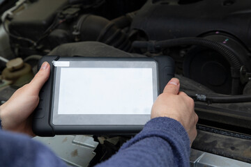 Car diagnostics. An auto mechanic performs car diagnostics using a scanner.
