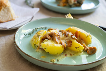 Boiled potatoes with chanterelle mushrooms in sour cream sauce