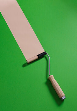 Concealer paint roller against green background