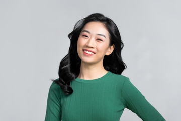 An attractive asian woman feeling happy in front of a white background