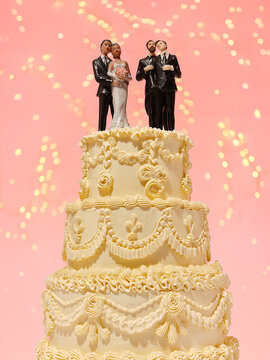 Wedding cake with LGBTQ and heterosexual couples against pink 