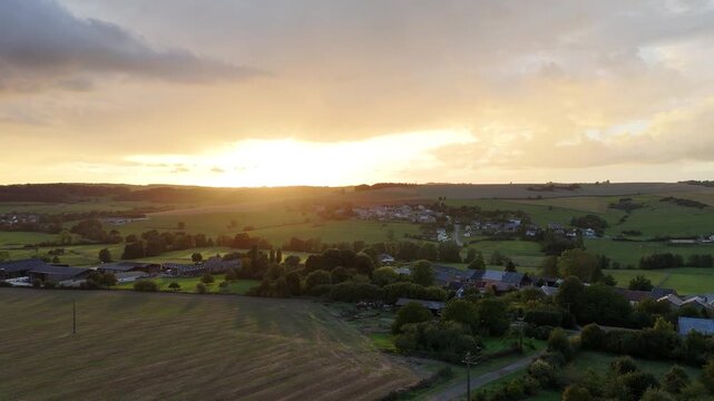 4K aerial drone footage of Saint-Marcel, France, capturing green countryside landscapes and a beautiful sunset over rural fields