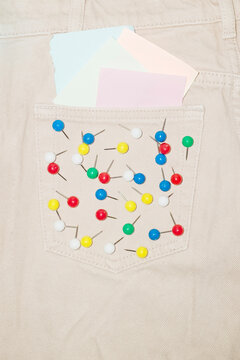Denim jeans and colourful paper pins on the pocket and flash